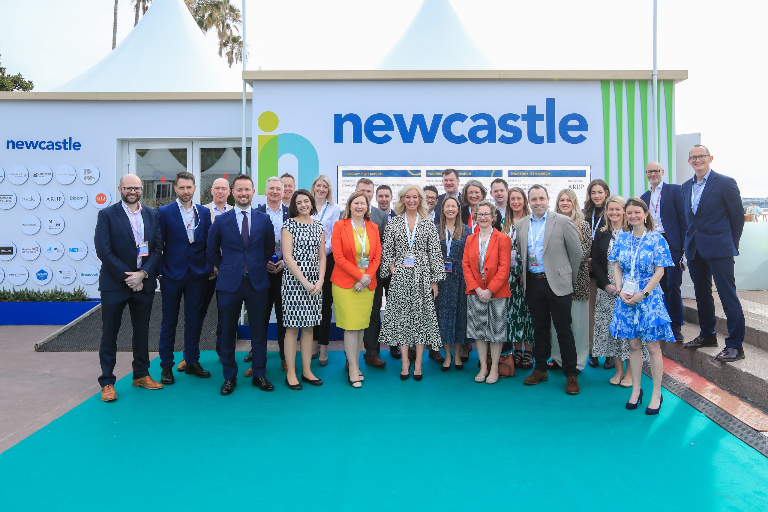 Team standing next to Invest Newcastle sign