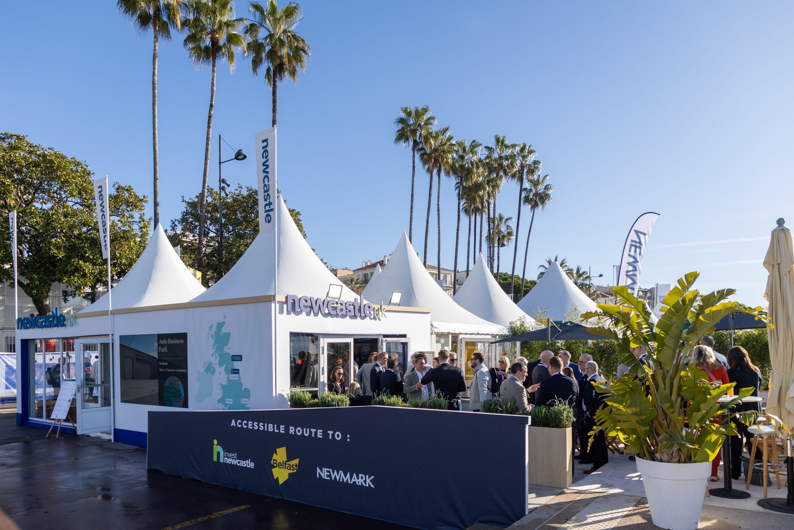 View of Newcastle stand at MIPIM with palm trees in the background