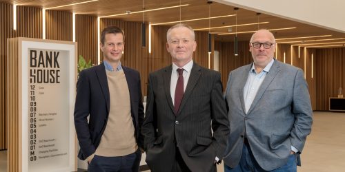 Three people posed in the Bank House reception area