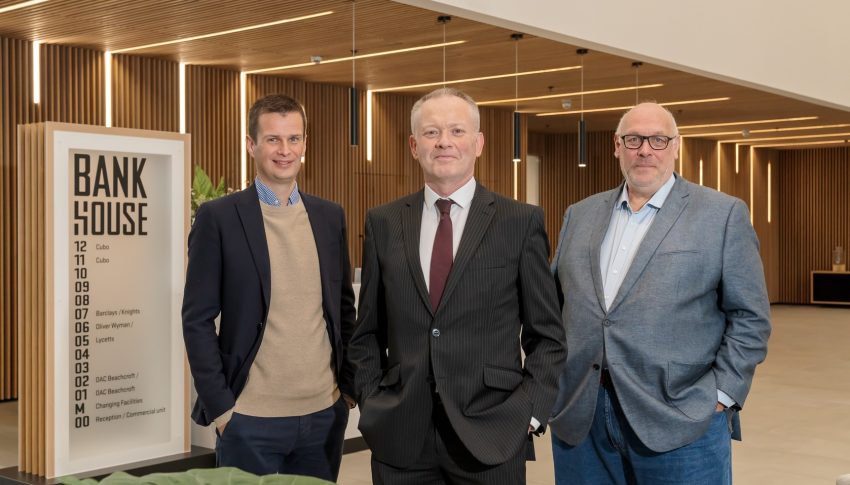 Three people posed in the Bank House reception area