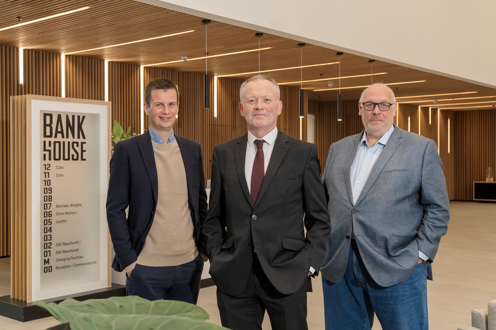 Three people posed in the Bank House reception area