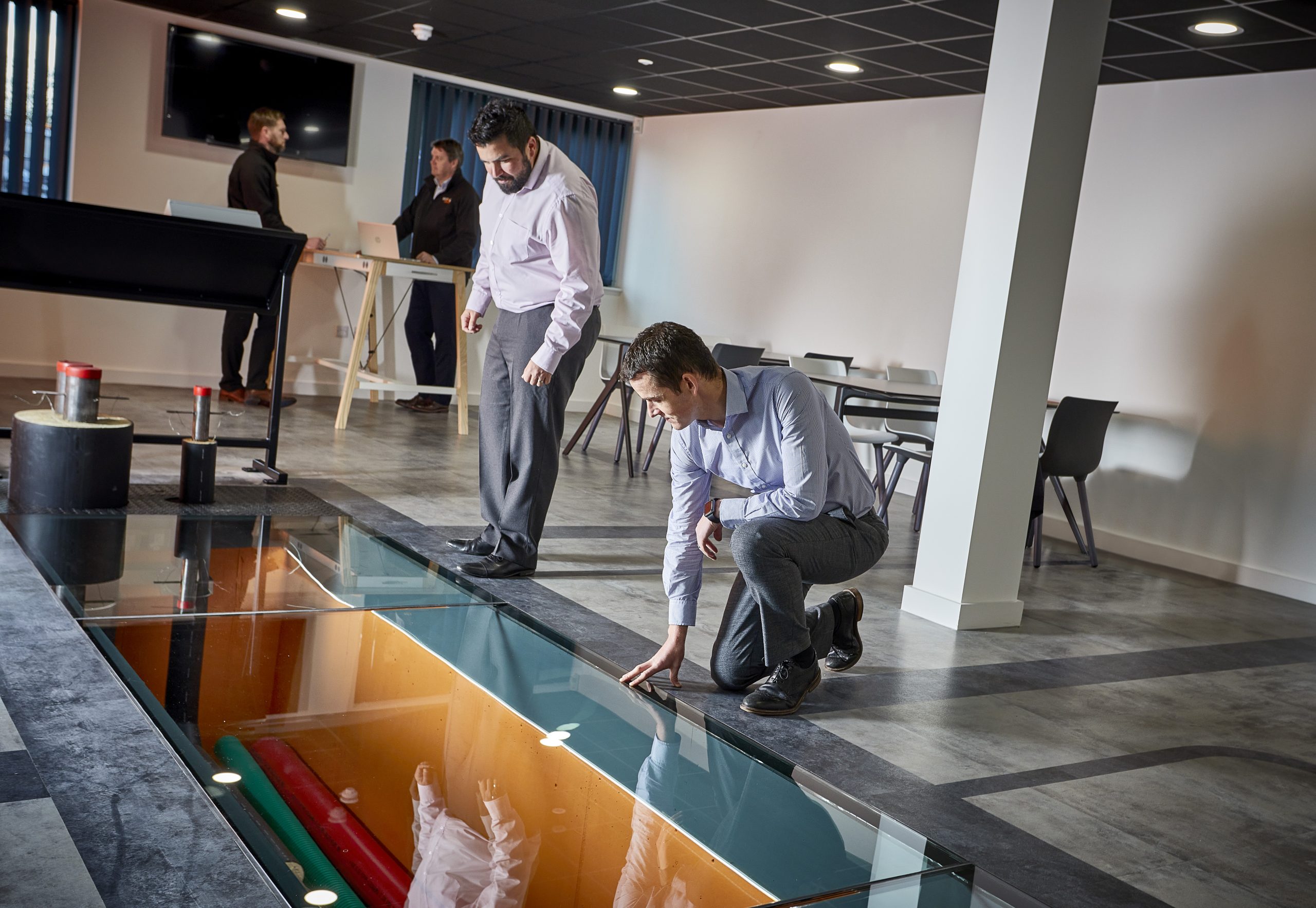 A photograph of two people inspecting energy infrastructure and equipment