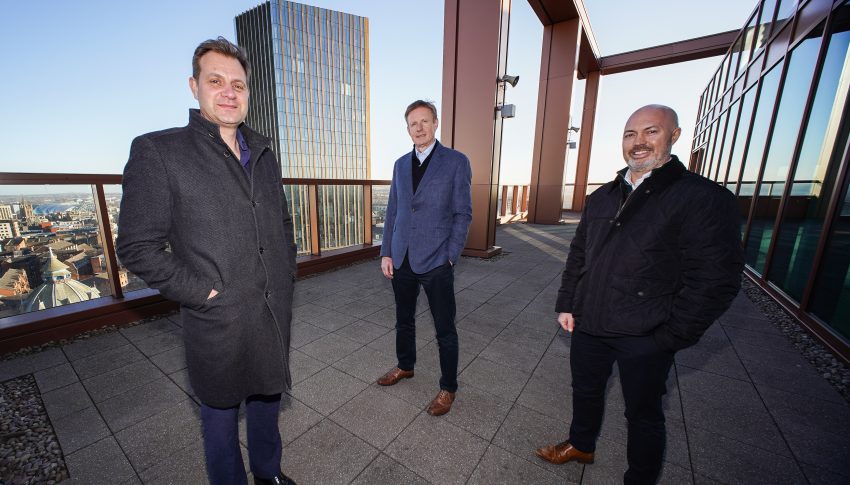 Three people from Broadoak and Tier One Captial on a terrace overlooking the Newcastle skyline.