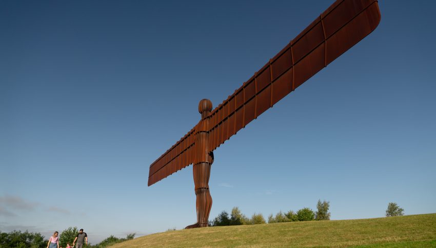 Angel of the North statute on the top of a hill in the sunshine.