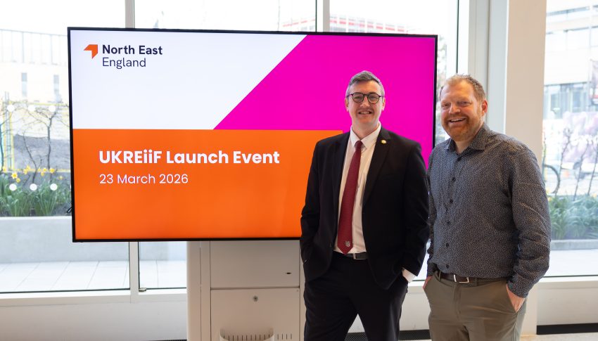 Cllr Mordey and Phil Witcherley standing together in front of the UKREiiF launch event presentation screen.