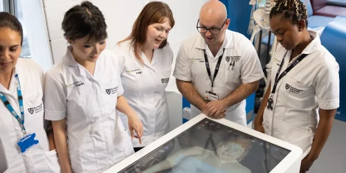 Group of students receiving training by a senior medical professional